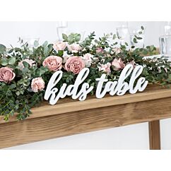 Valkoinen puinen kyltti "kids table".