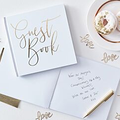 Valkoinen vieraskirja kultaisella tekstillä "Guest Book".